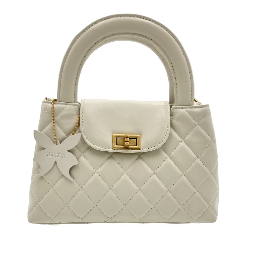 Beige real leather handbag with a butterfly charm and gold accent on a white background