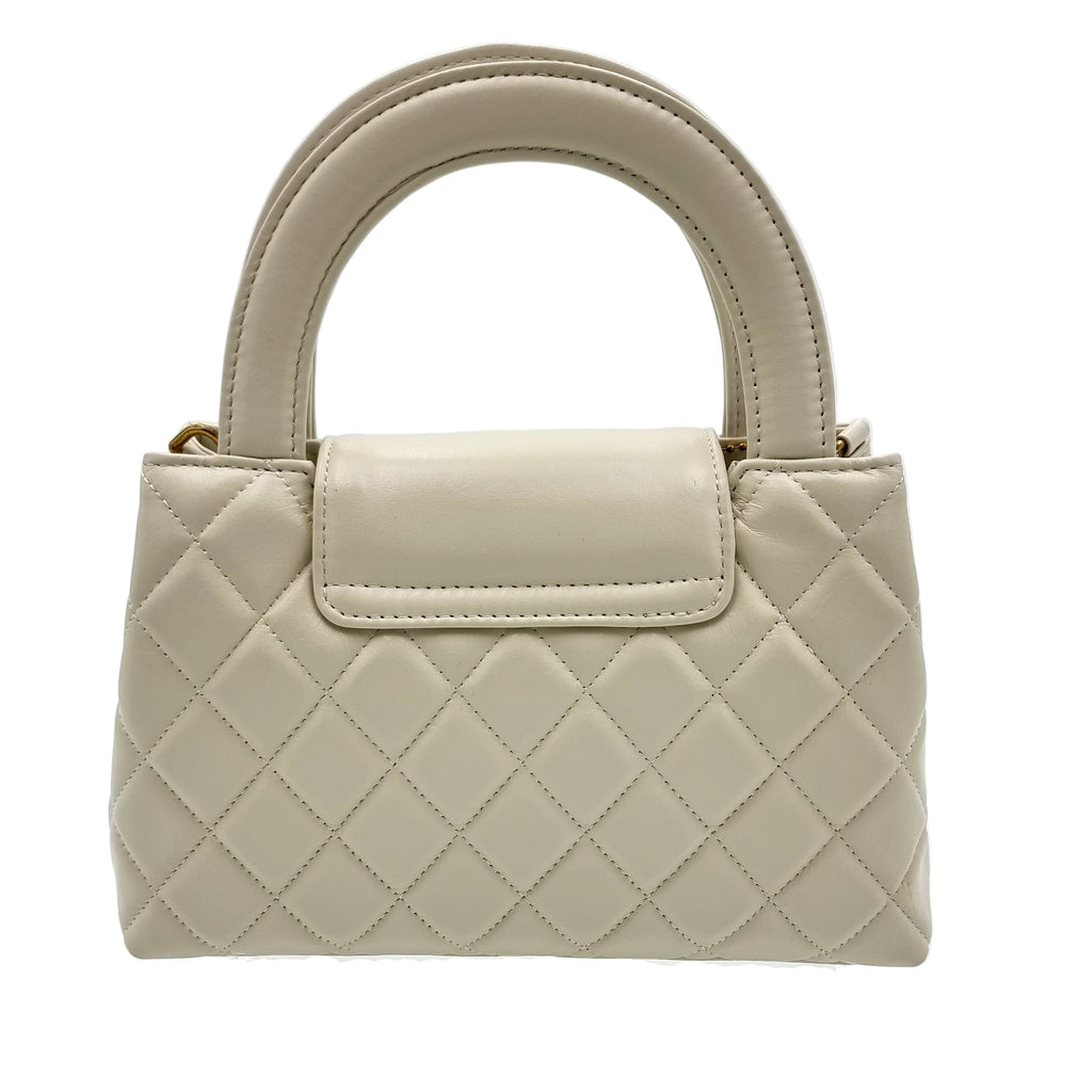 Beige real leather quilted handbag on a white background