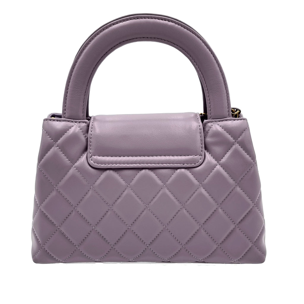 Quilted purple real leather handbag on a white background