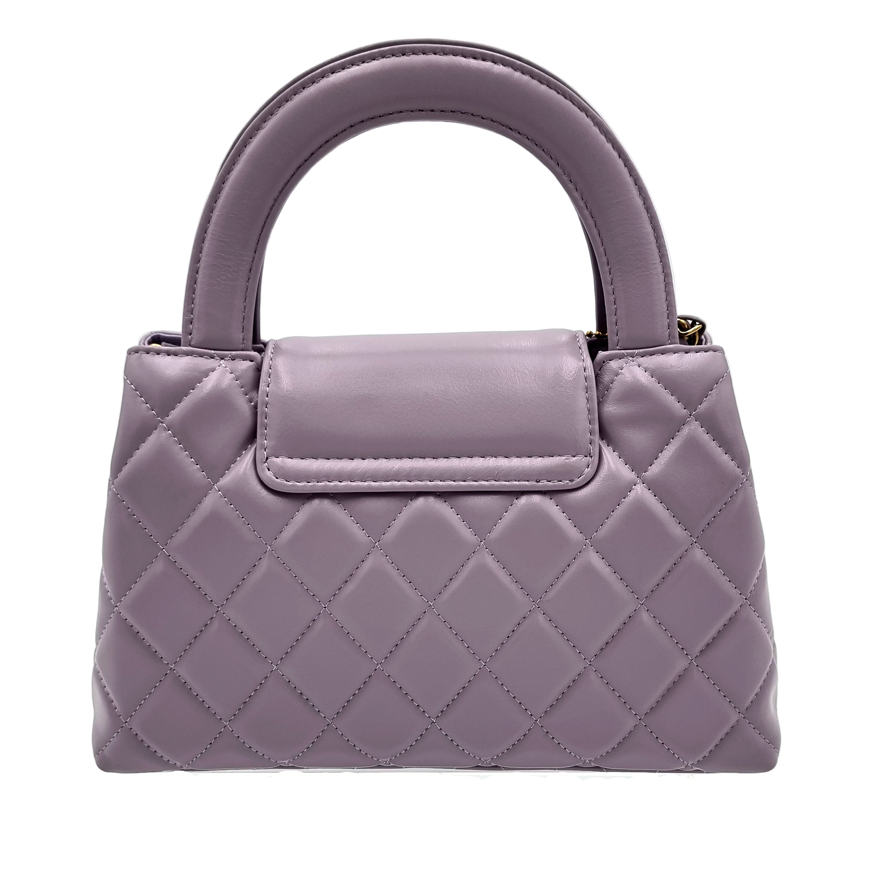 Quilted purple real leather handbag on a white background
